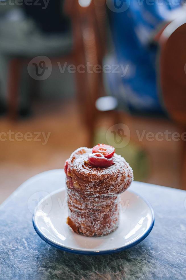 fechar acima do cruffin ou kraffin dentro uma pequeno branco prato com bokeh foto