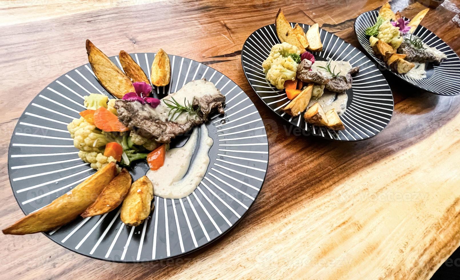 suculento carne bife com salada e batata cunhas ao longo com Pimenta milho molho foto