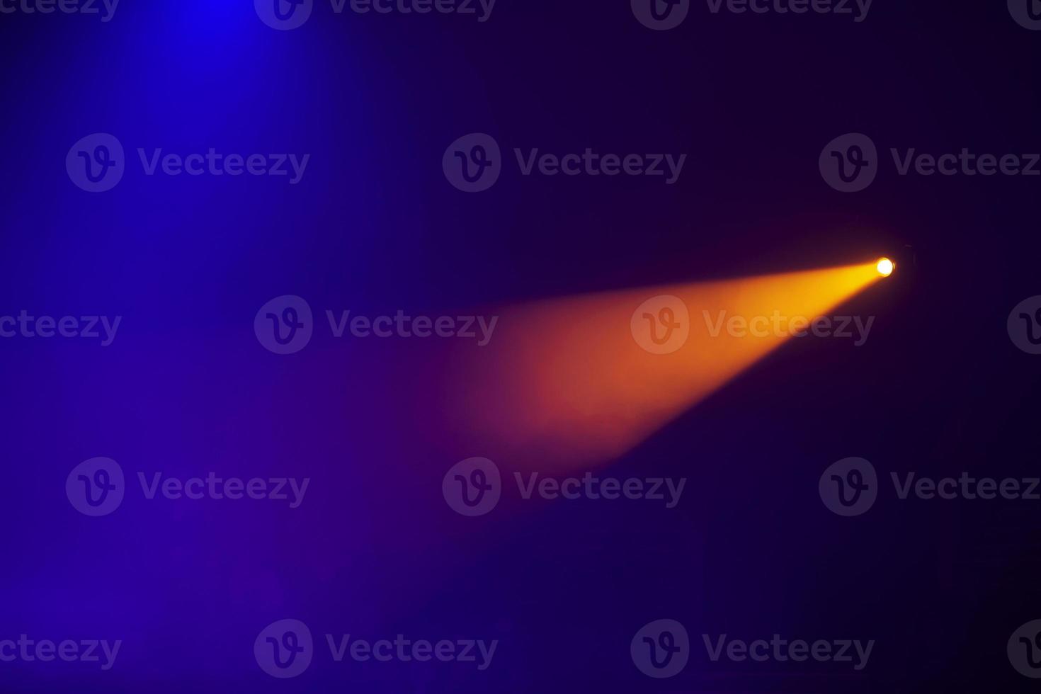 laranja feixes do luz a partir de etapa holofotes em uma Sombrio azul background.illumination do a estágio. foto