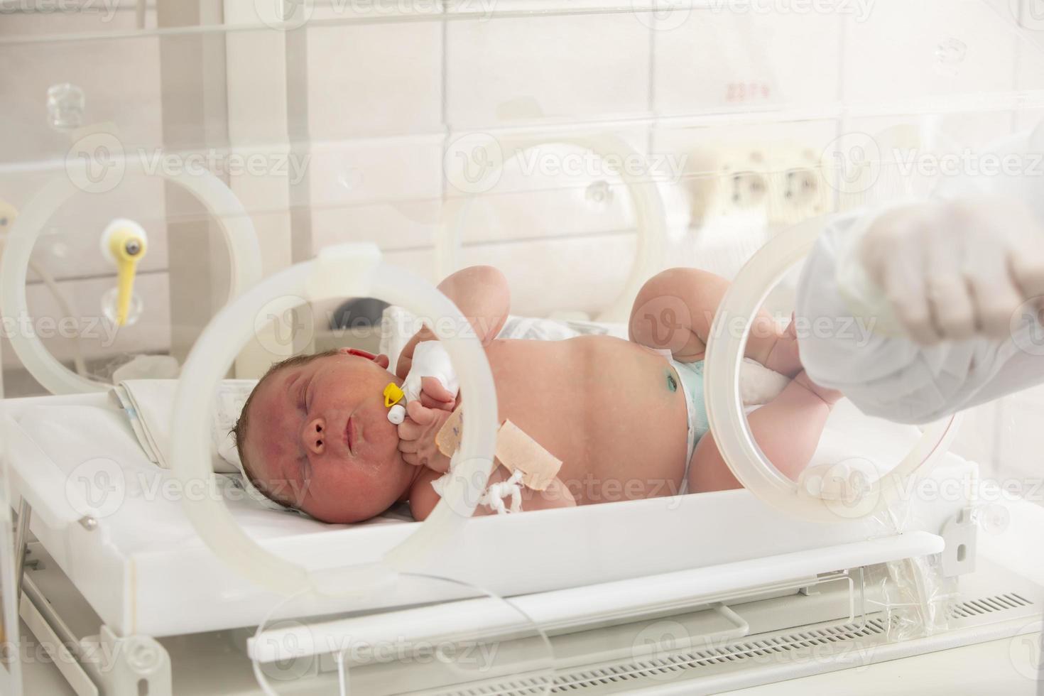 um bebê recém-nascido encontra-se em caixas no hospital. uma criança em uma incubadora. Unidade de Terapia Intensiva Neonatal e Prematuro foto