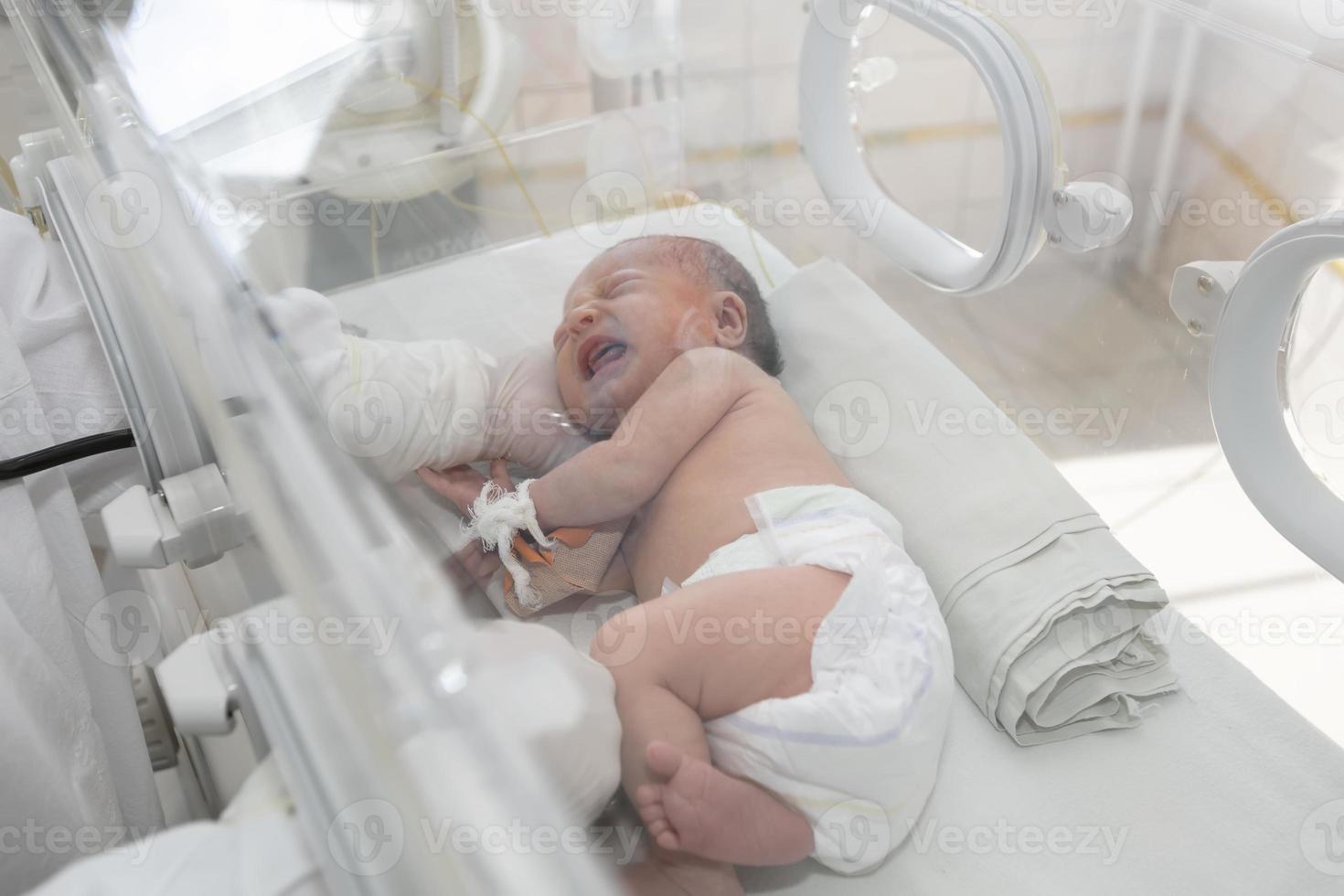 um bebê recém-nascido encontra-se em caixas no hospital. uma criança em uma incubadora. Unidade de Terapia Intensiva Neonatal e Prematuro foto