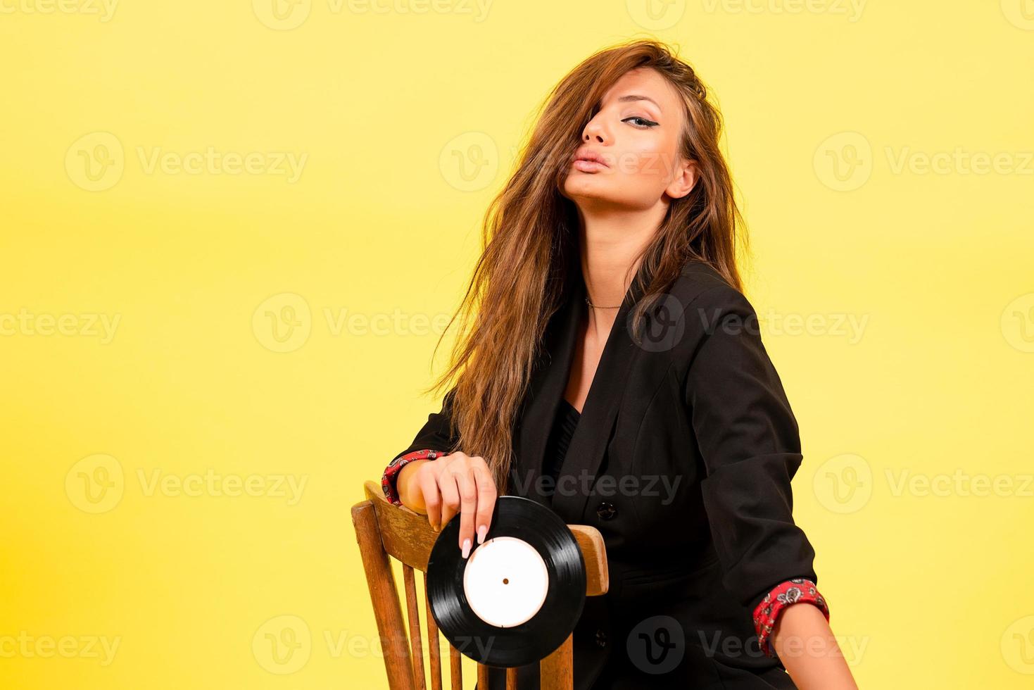 menina dentro uma Preto terno em uma amarelo fundo, elegante menina foto