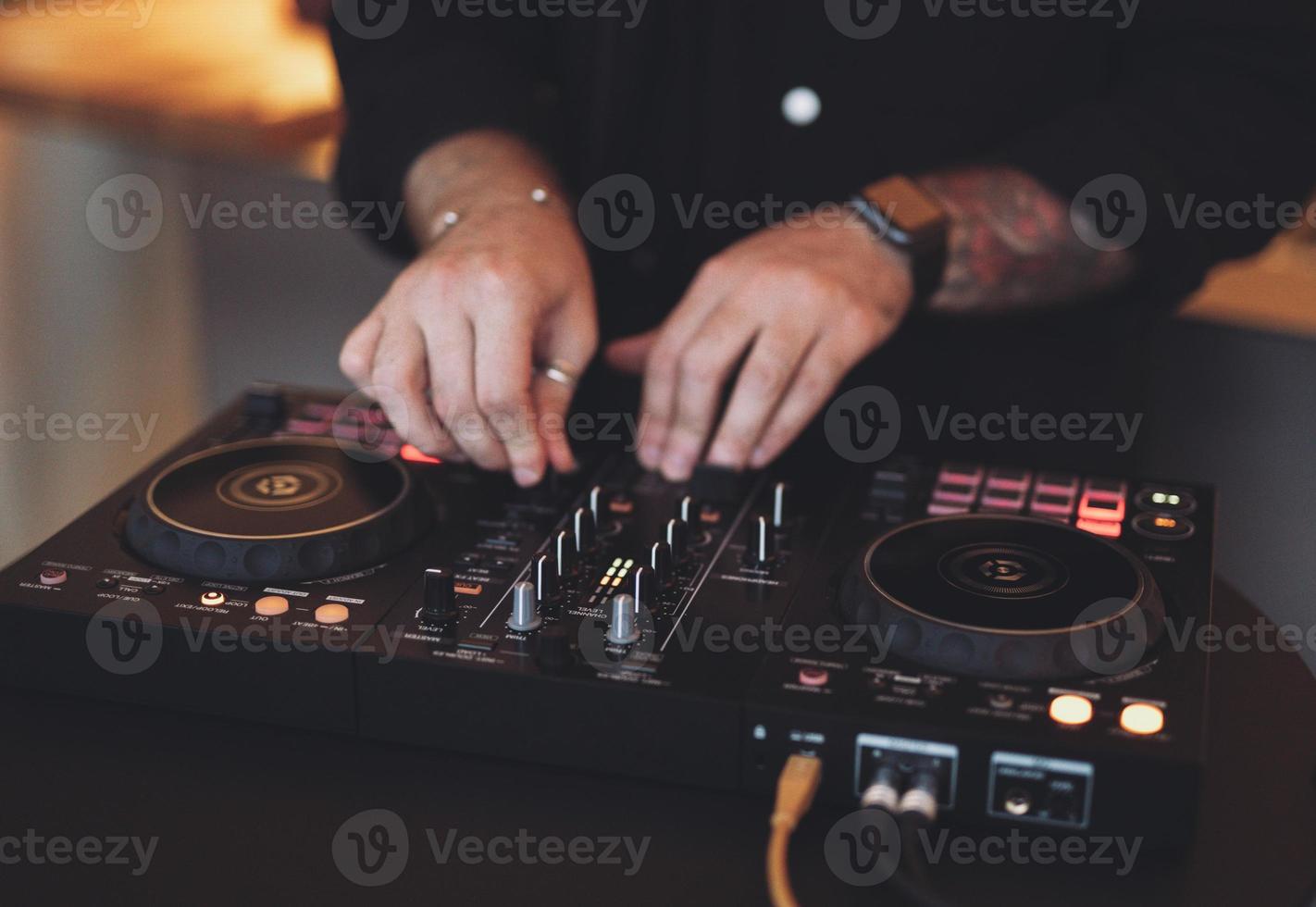 um dj toca música em um controlador em uma festa. foto