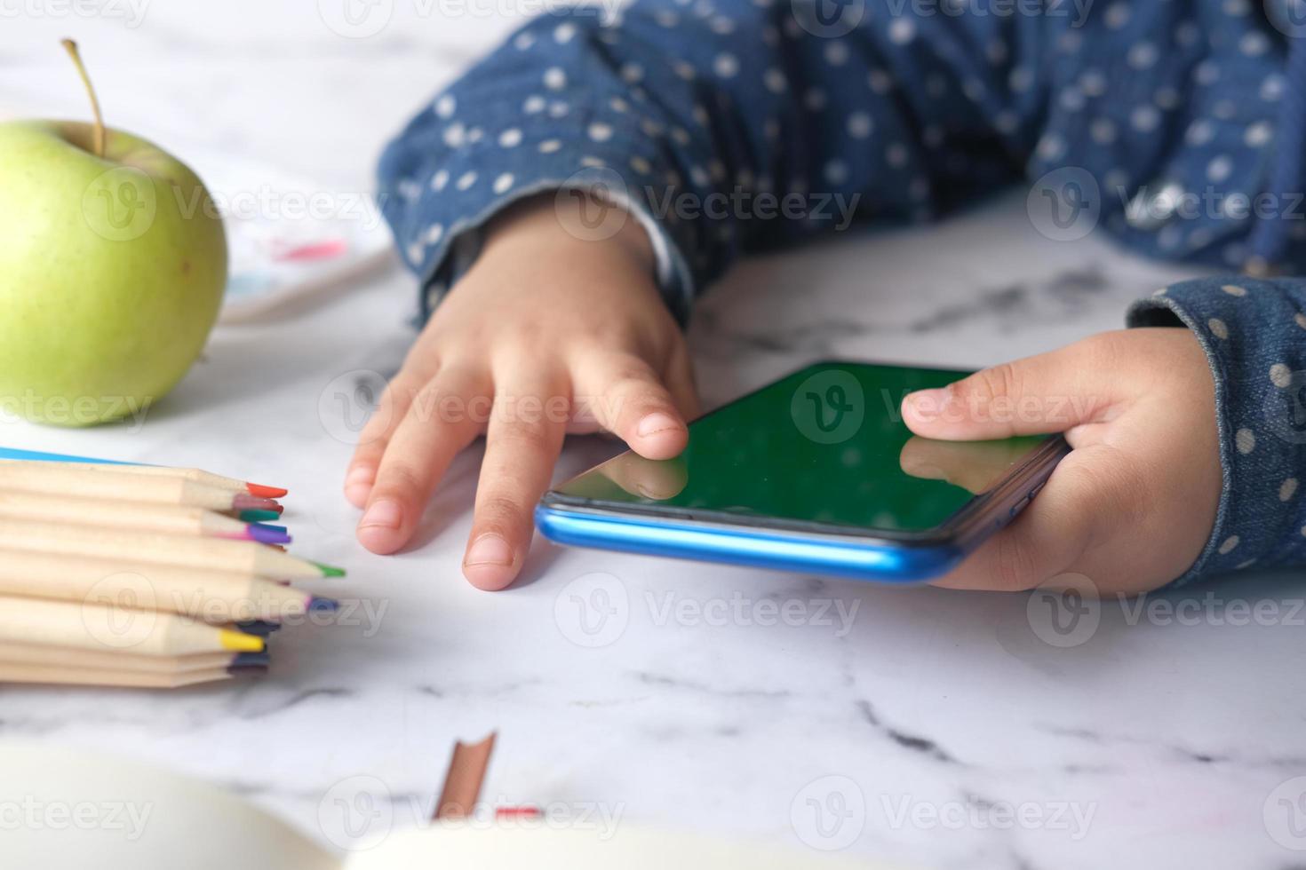 menina criança assistindo desenhos animados no telefone inteligente foto