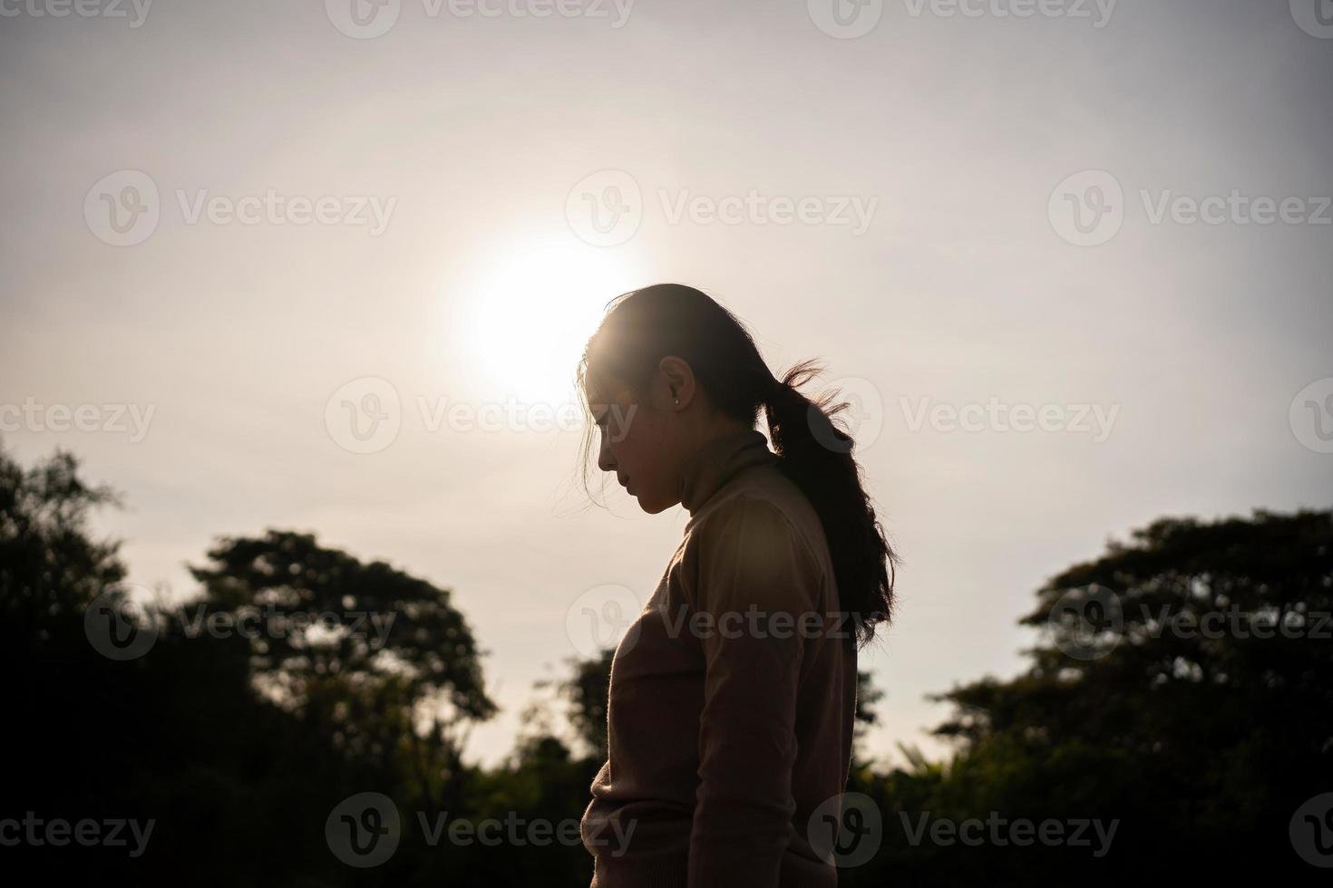 ásia mulheres ela sentido solitário e sozinho às pôr do sol. silhueta foto. foto