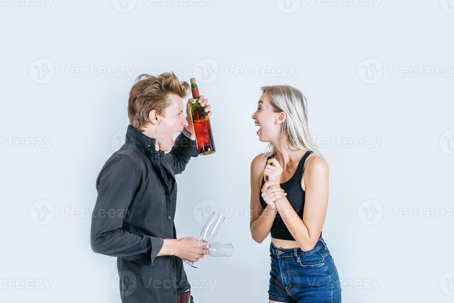 retrato de jovem casal feliz bebendo vinho em estúdio foto