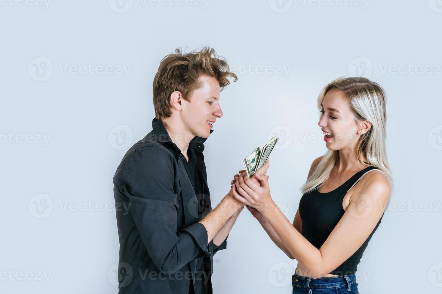 casal feliz mostrando notas de dólar foto