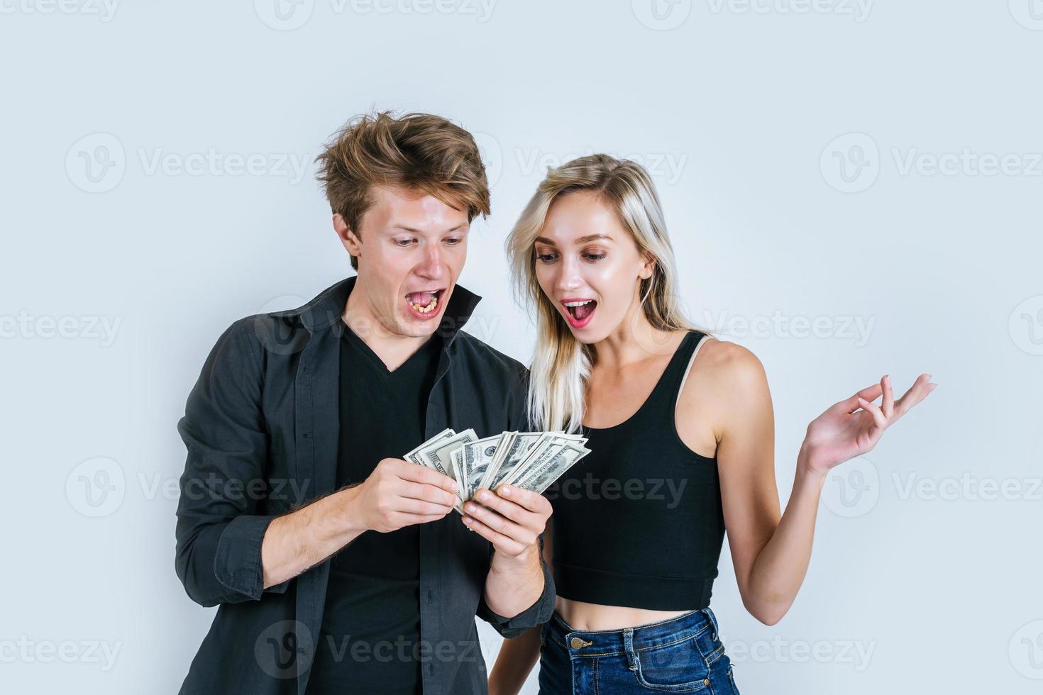 casal feliz mostrando notas de dólar foto