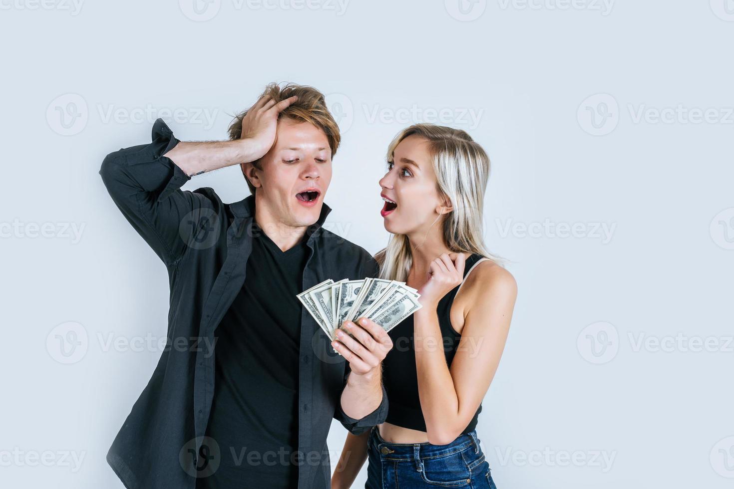 casal feliz mostrando notas de dólar foto