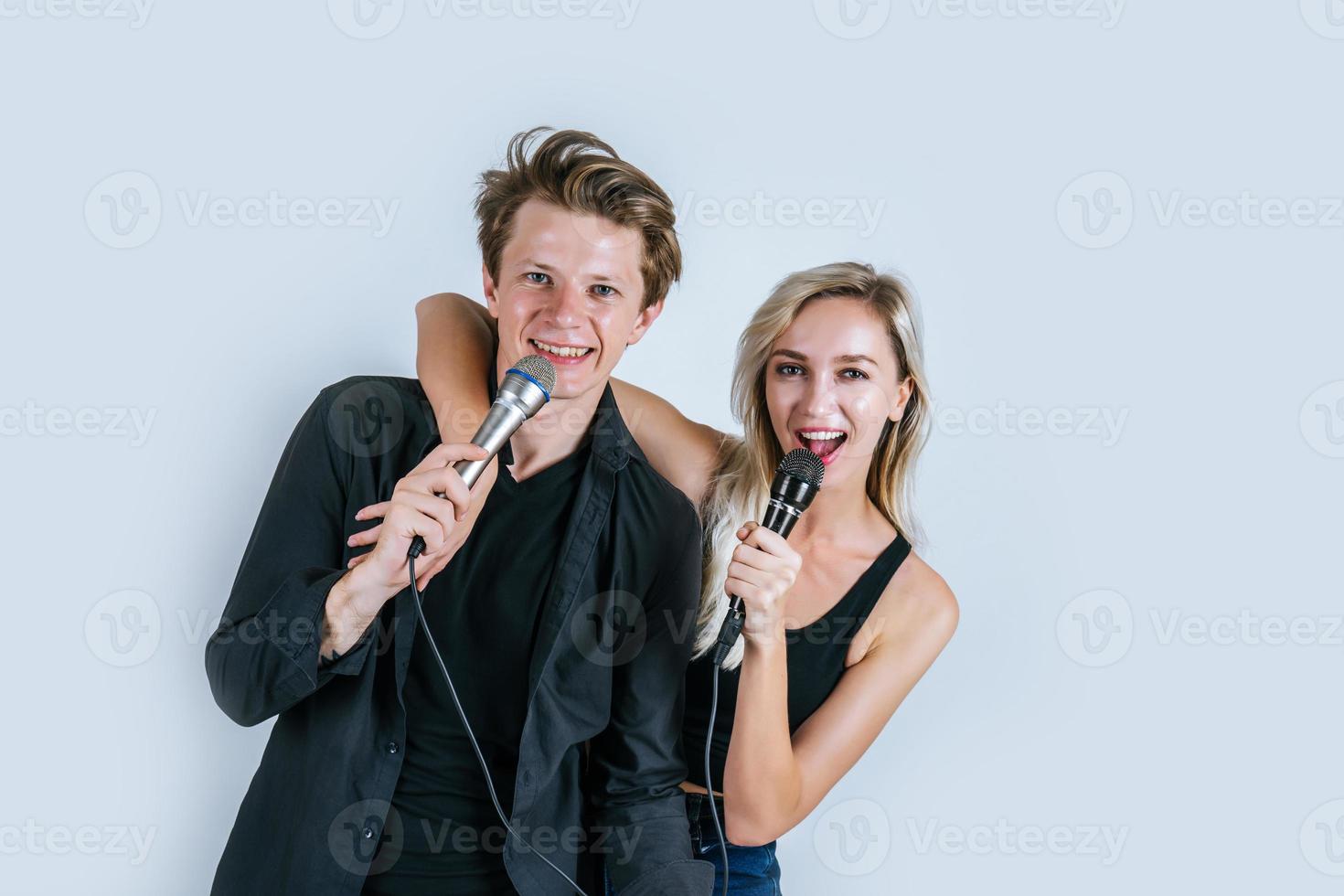 feliz retrato de casal segurando microfones e cantando foto