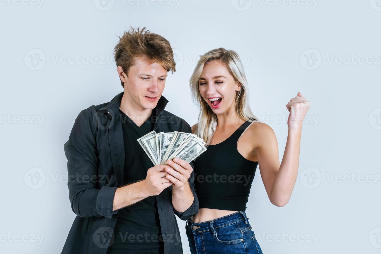 casal feliz mostrando notas de dólar foto