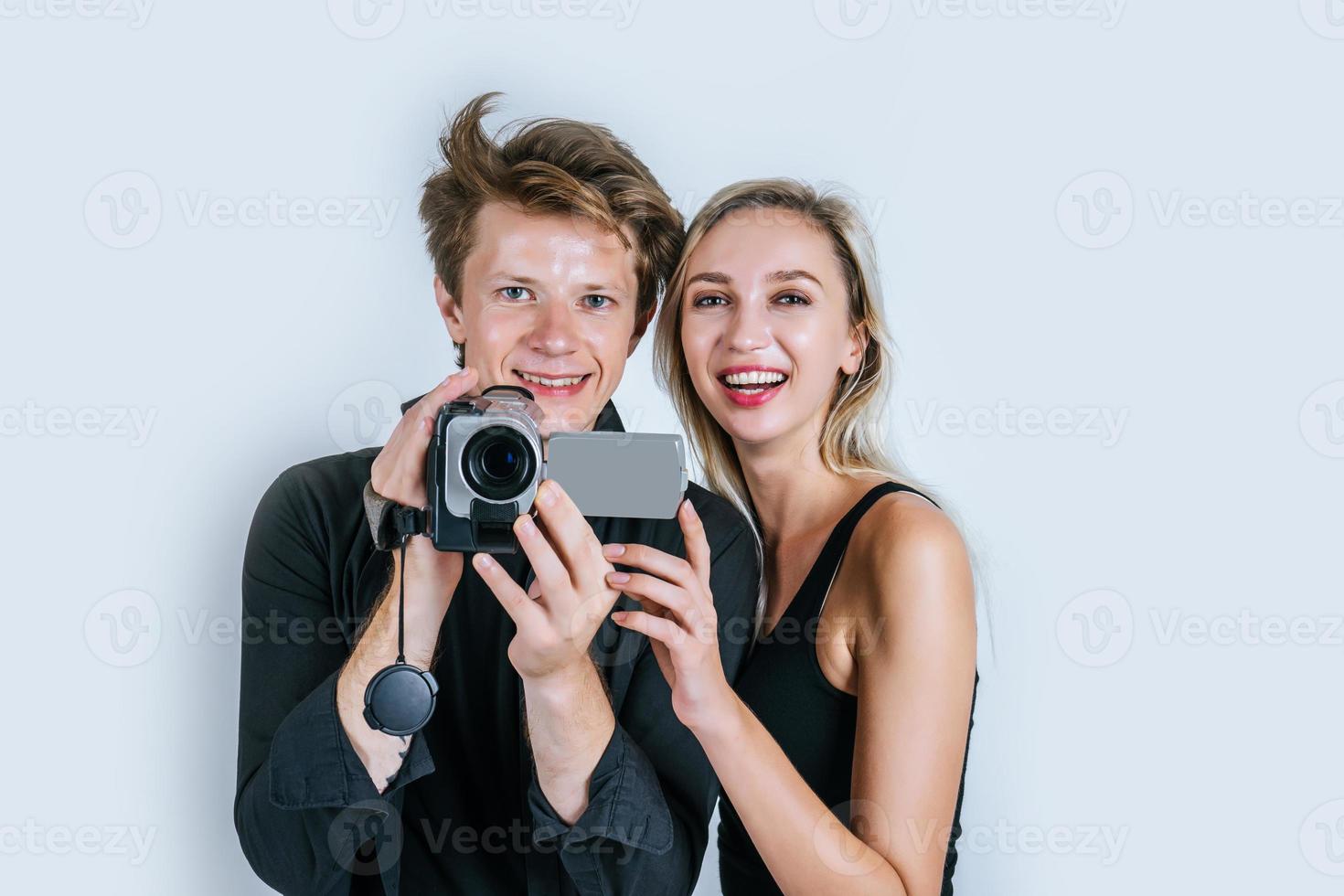 retrato feliz de casal segurando uma câmera de vídeo e gravando um vídeo foto