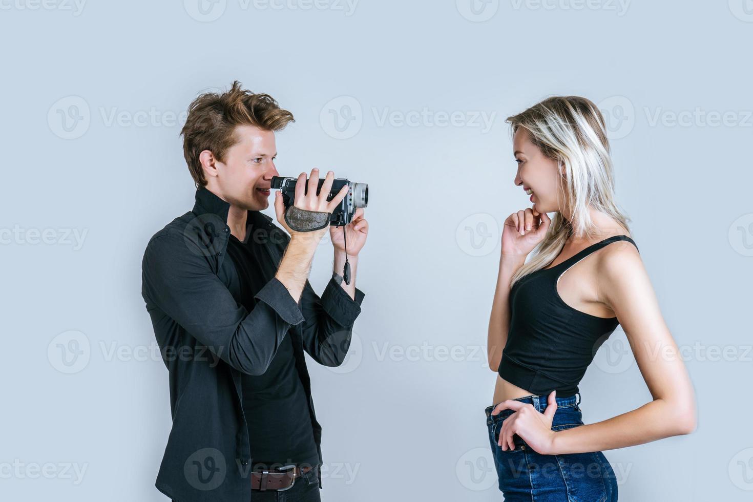 retrato feliz de casal segurando uma câmera de vídeo e gravando um vídeo foto