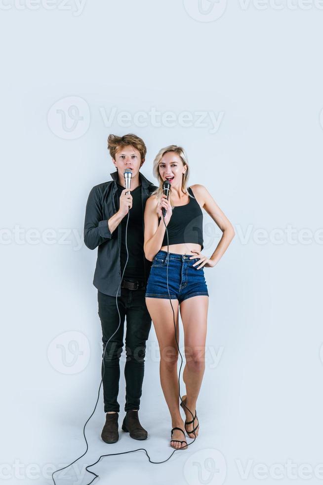 feliz retrato de casal segurando microfones e cantando foto