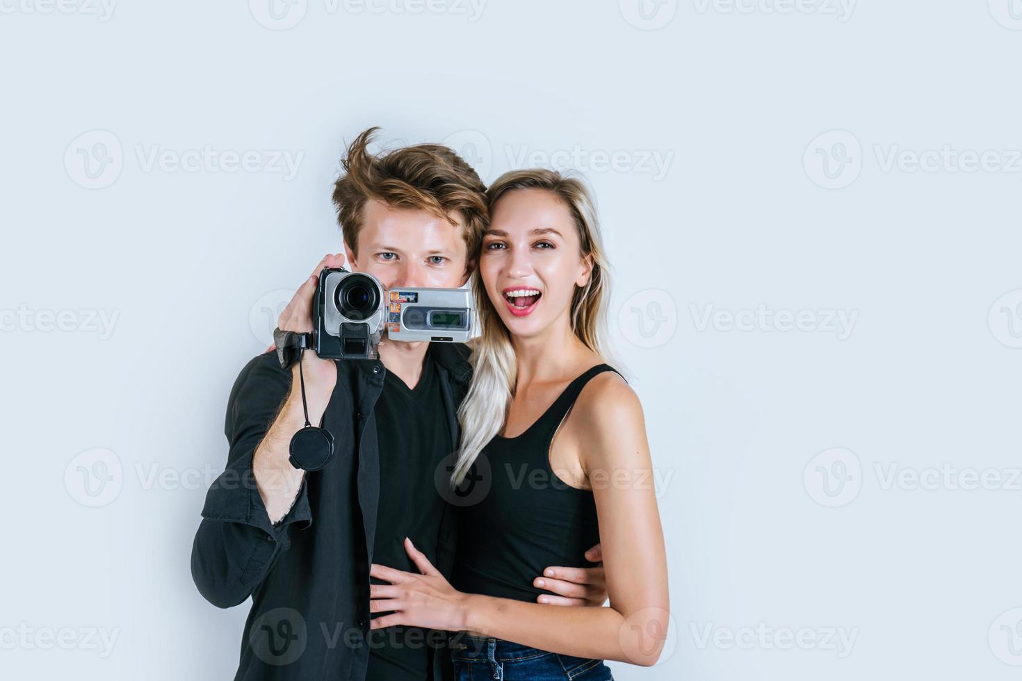 retrato feliz de casal segurando uma câmera de vídeo e gravando um vídeo foto