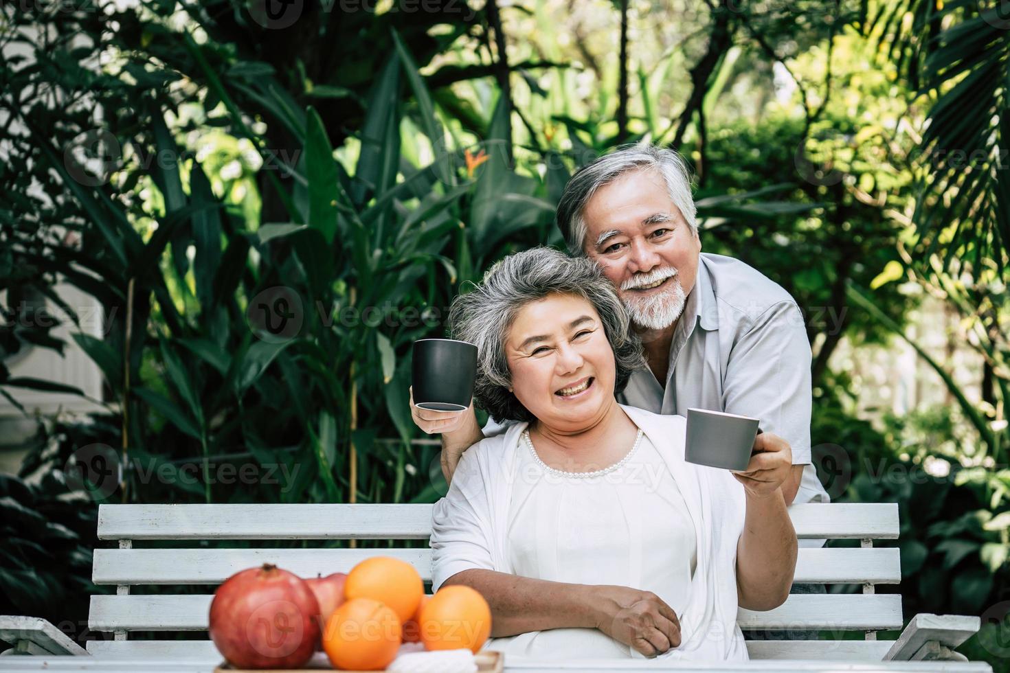 casal de idosos deitado e comendo frutas foto