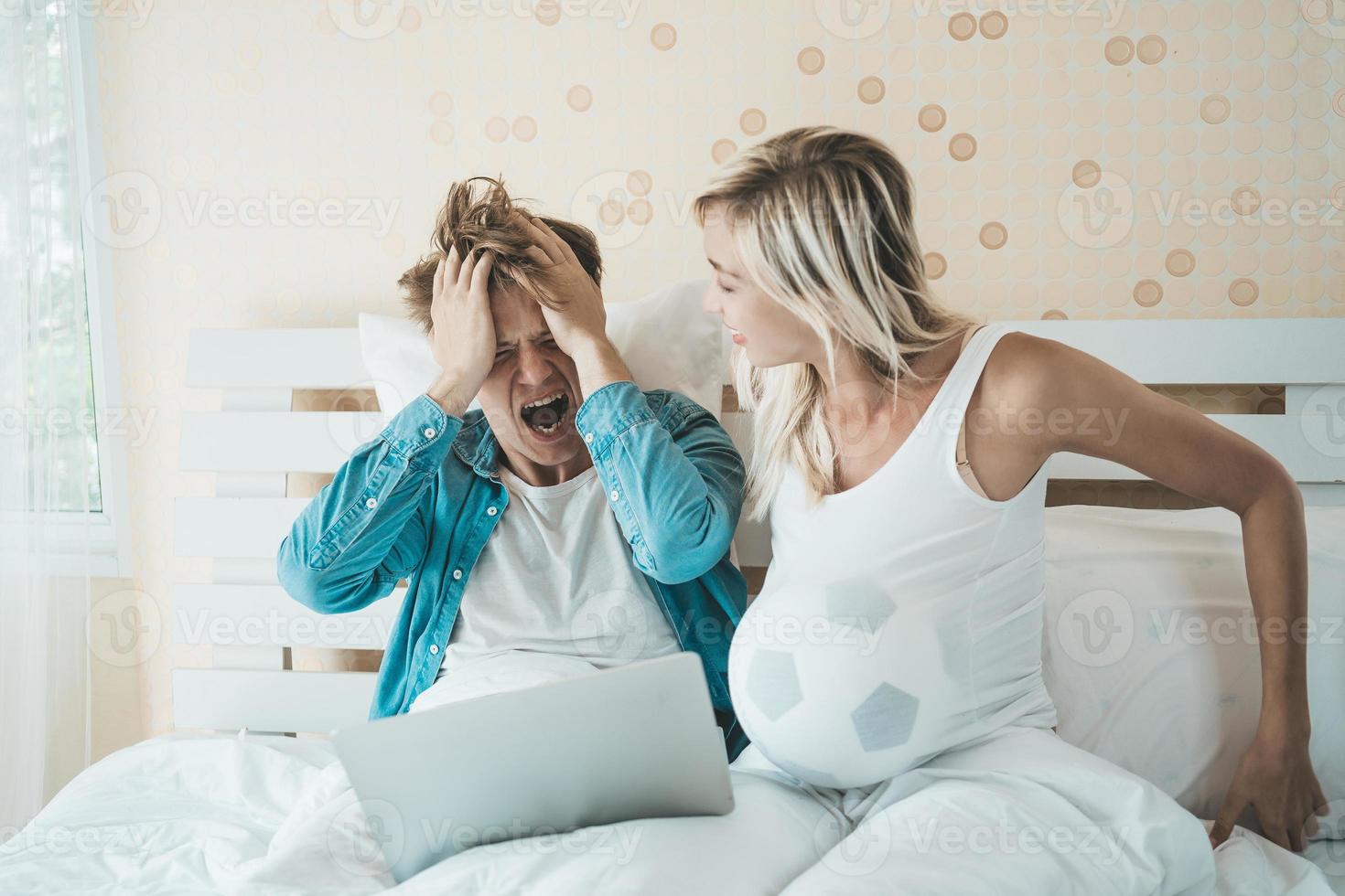 casal feliz assistindo futebol futebol na cama foto