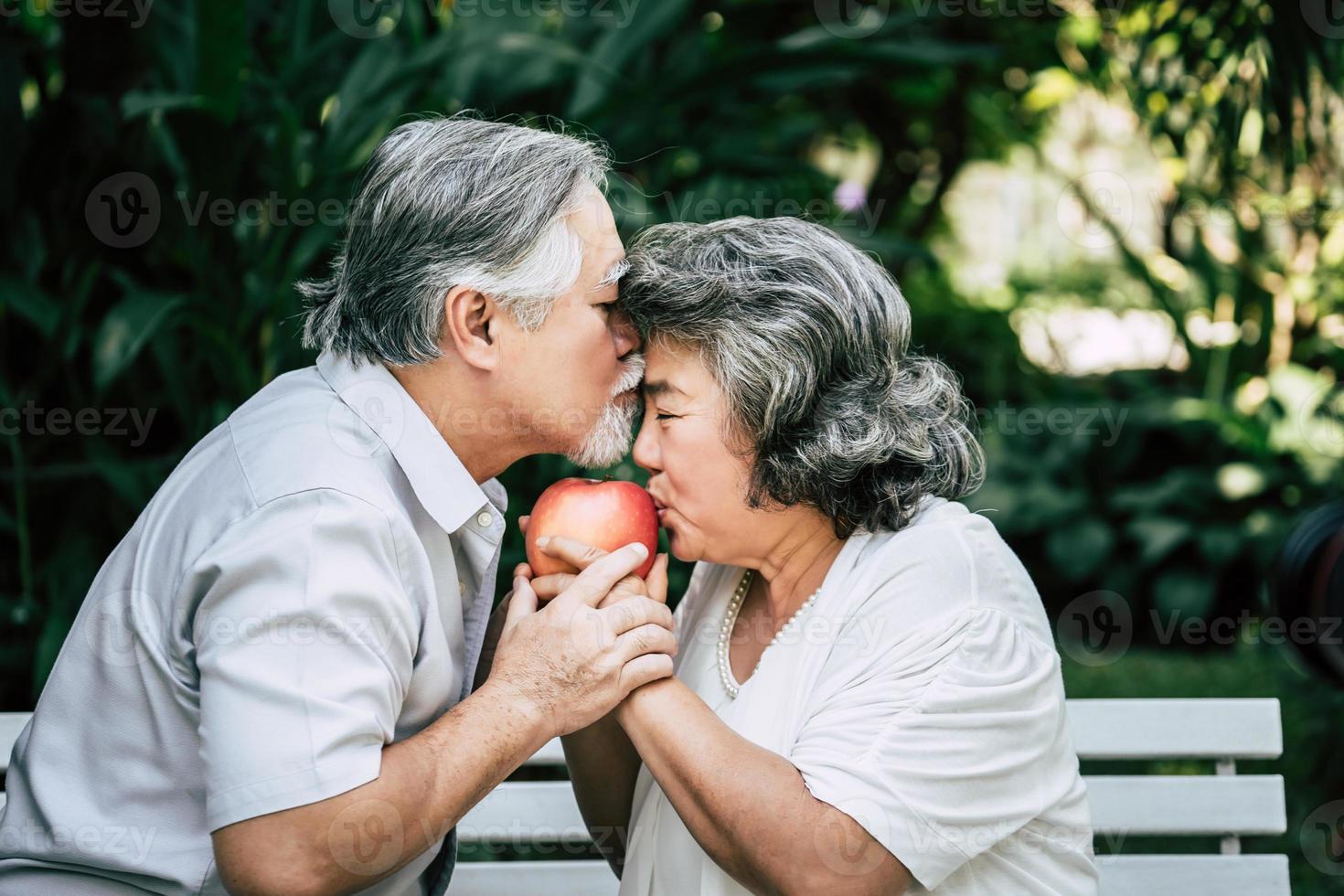 casal de idosos brincando e comendo frutas foto