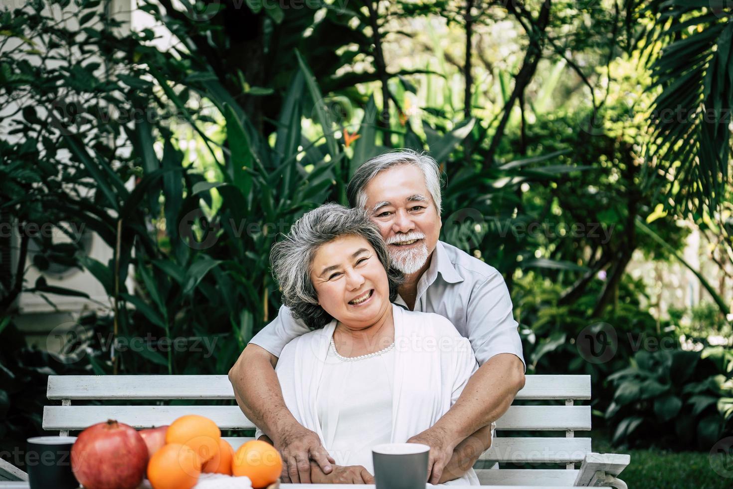 casal de idosos brincando e comendo frutas foto