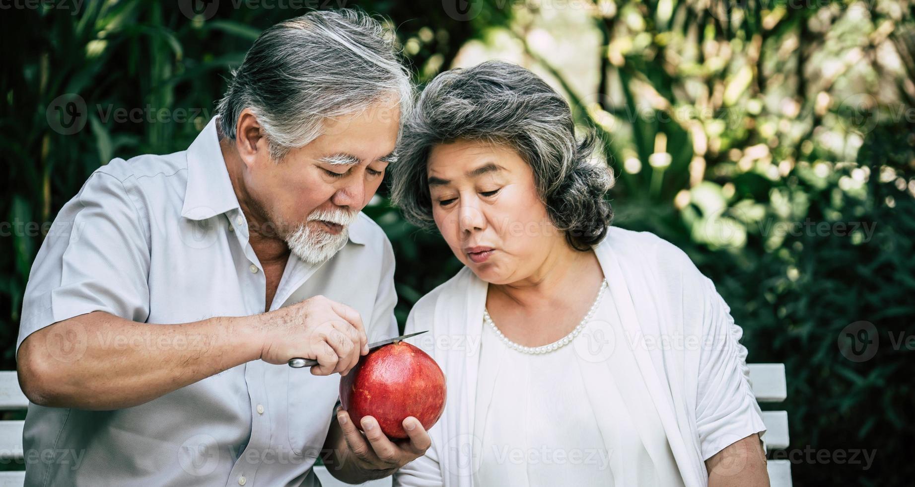 casal de idosos fatiando e comendo frutas foto