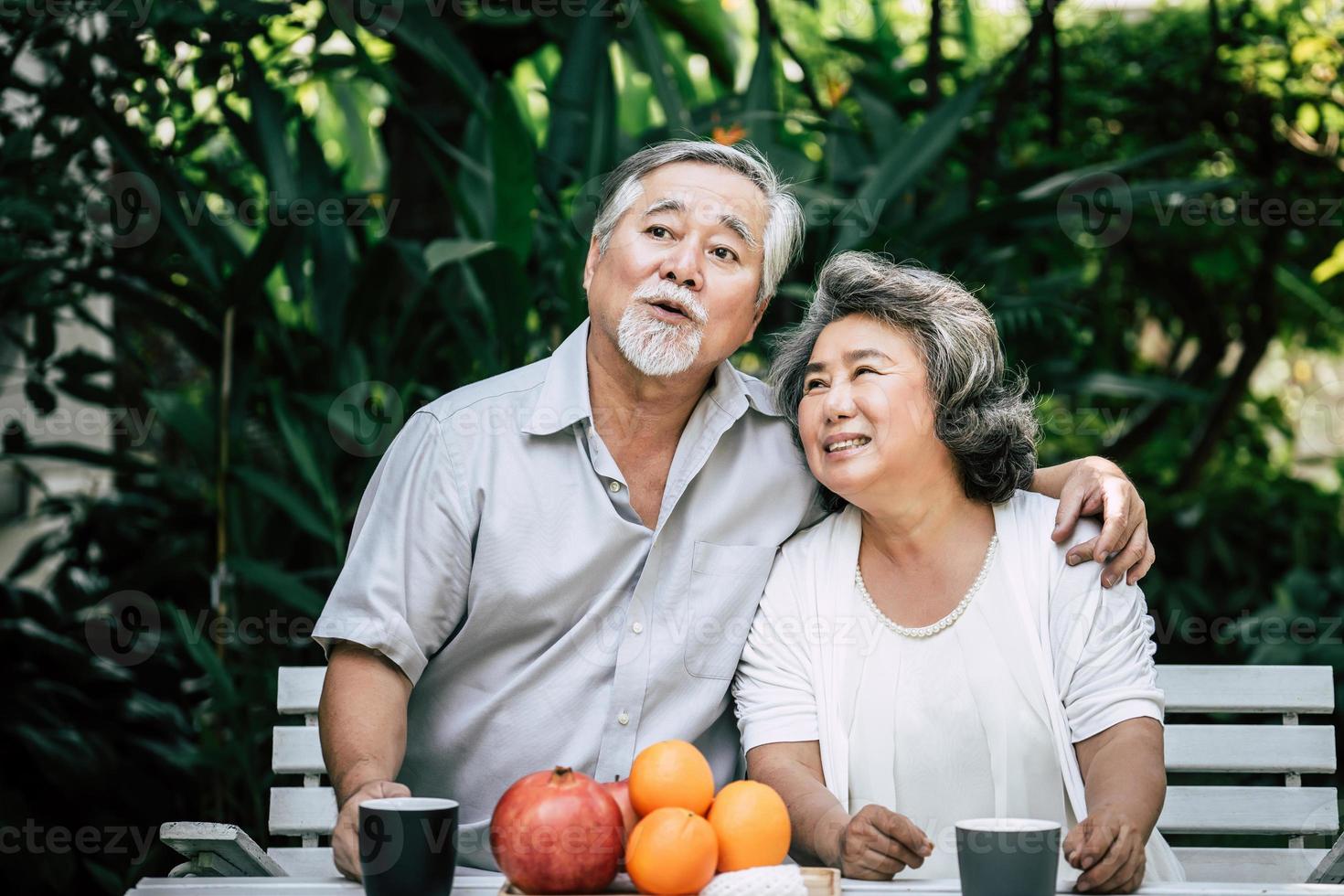 casal de idosos brincando e comendo frutas foto