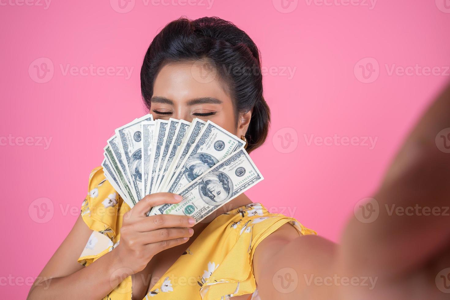 mulher feliz na moda segurando dinheiro foto