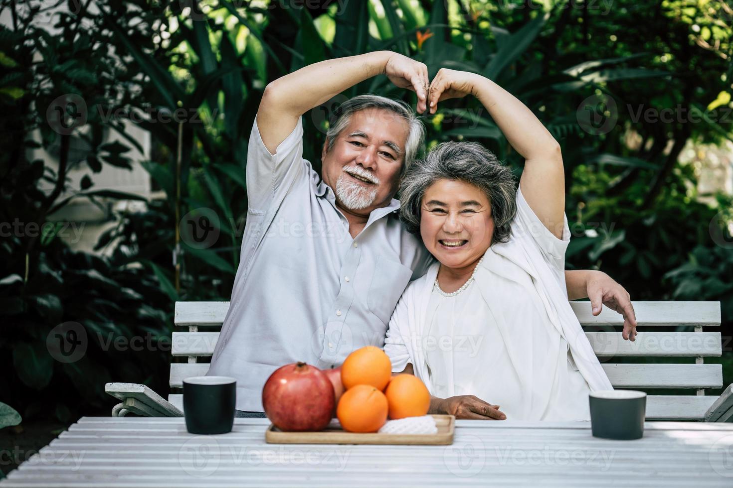 casal de idosos brincando e comendo frutas foto