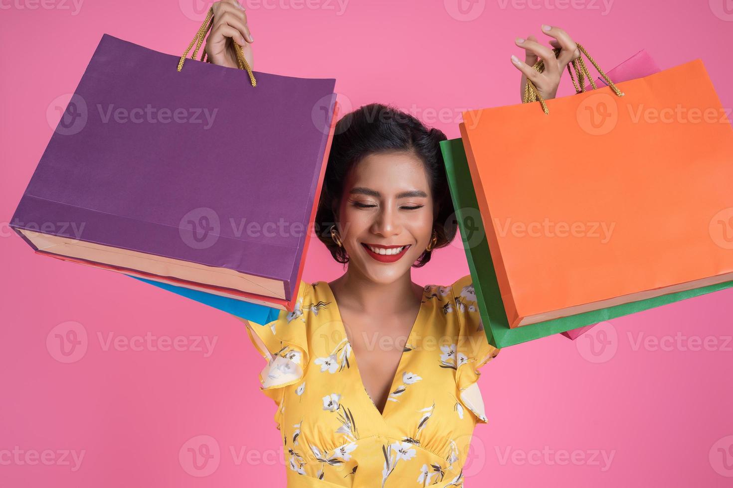 linda mulher asiática segurando sacolas coloridas foto