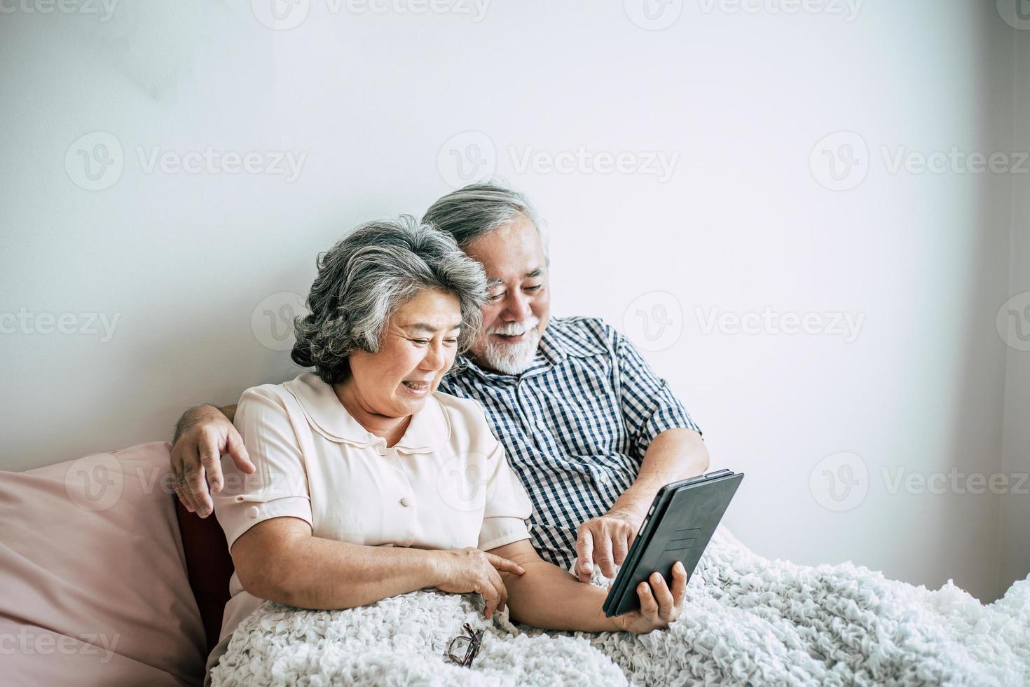 casal de idosos usando um computador tablet foto