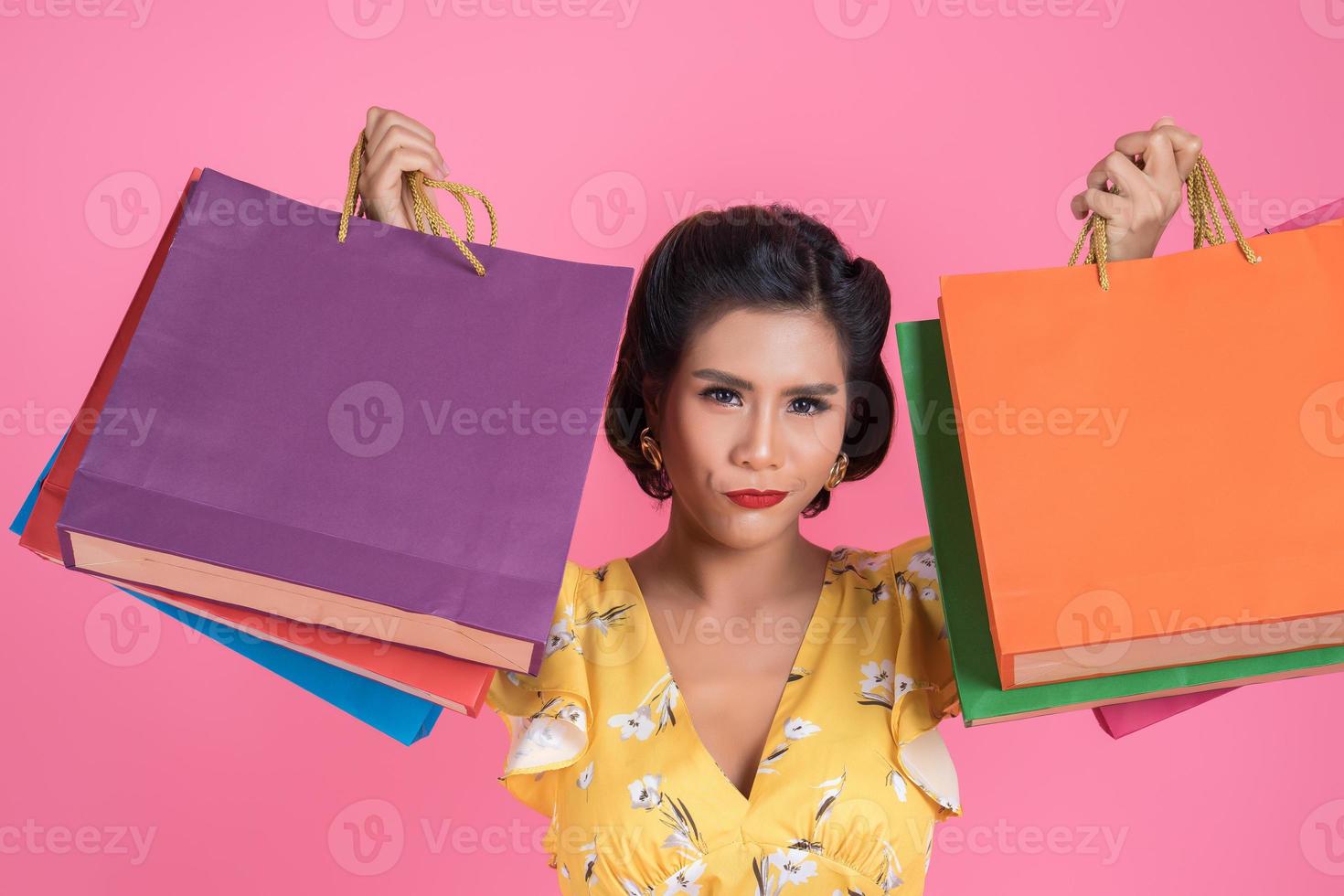 linda mulher asiática segurando sacolas coloridas foto