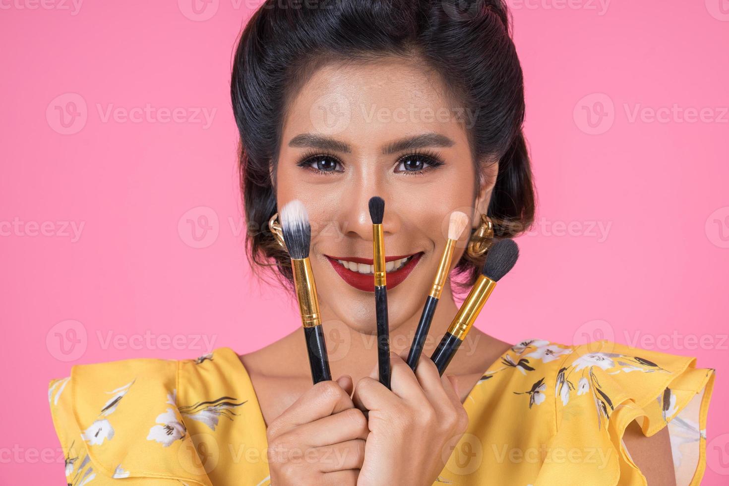 retrato de uma mulher com pincéis de maquiagem foto