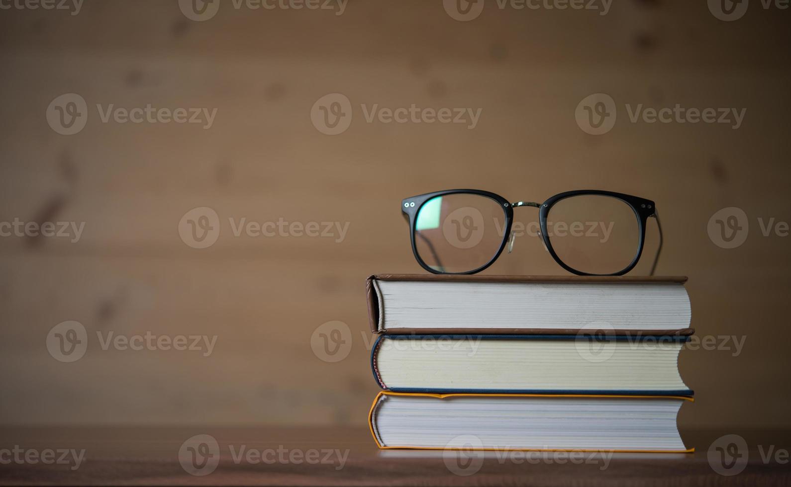 copos na pilha de livros na mesa de madeira foto