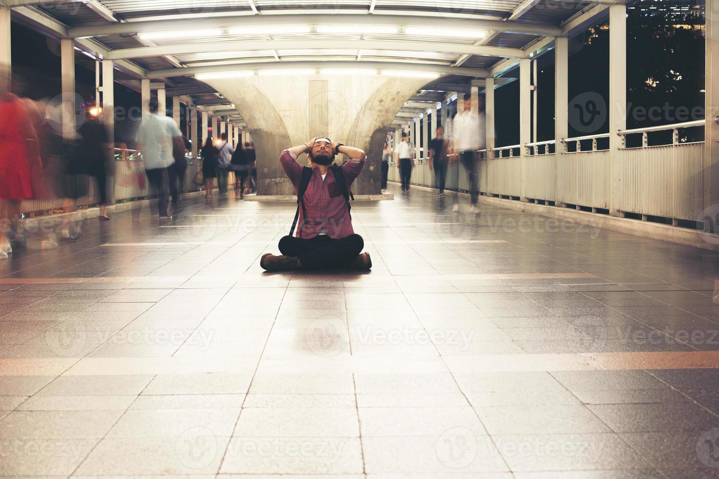 hipster barbudo sentado no chão sentindo-se estressado foto