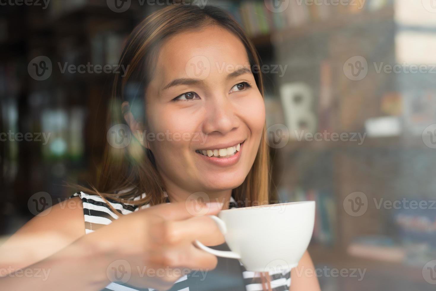 mulher asiática relaxando com um café no café foto