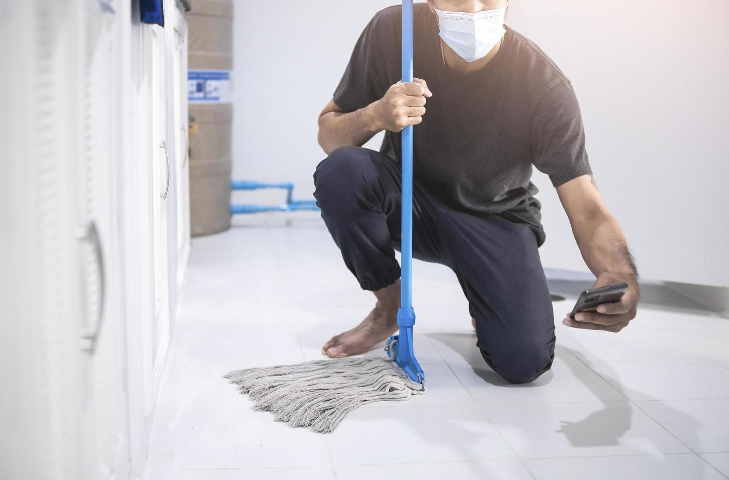 homem asiático limpando com um esfregão foto