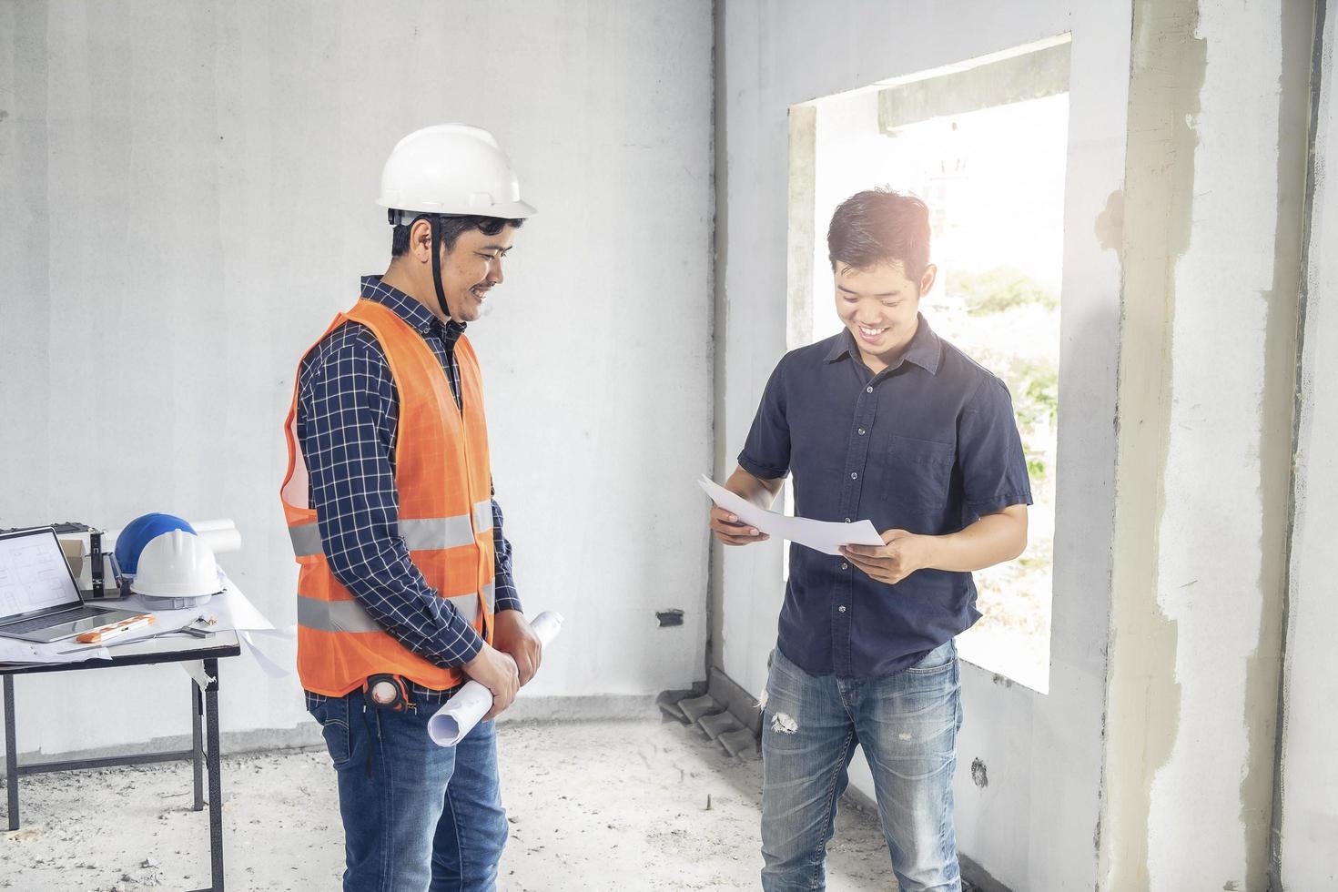 dois inspetores examinando planos de construção foto