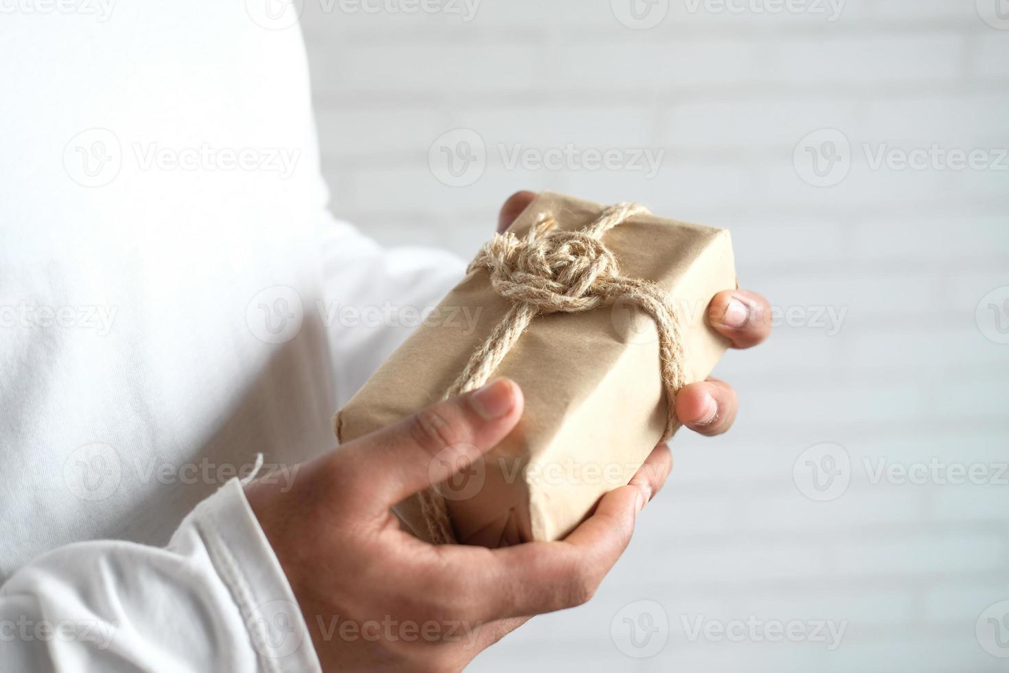 mão de homem segurando uma caixa de presente com espaço de cópia foto