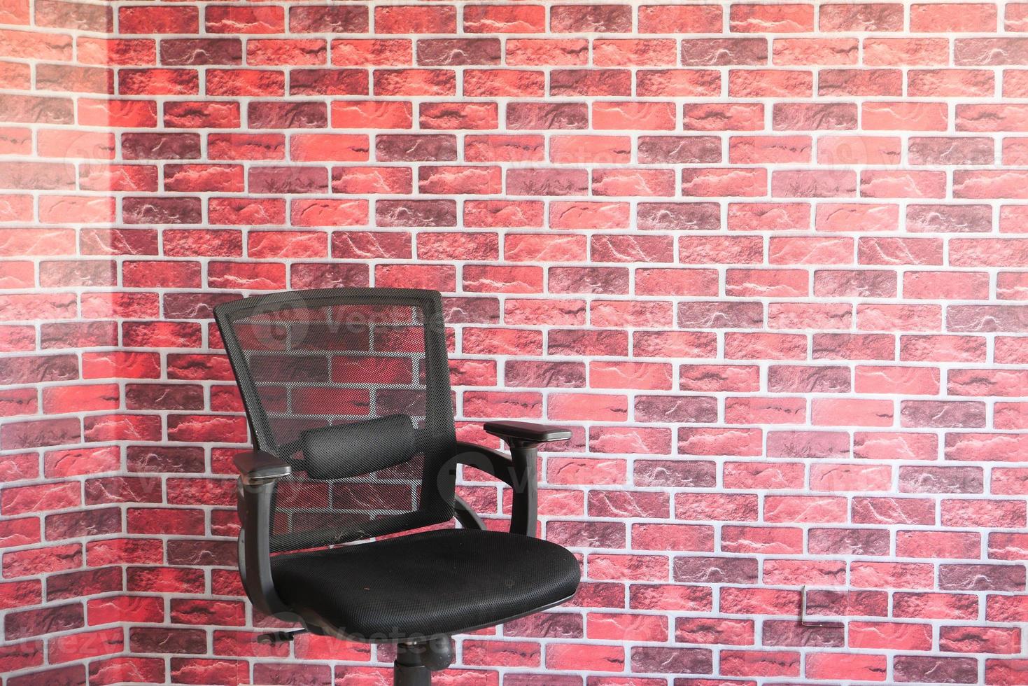 cadeira preta vazia contra uma parede interna foto