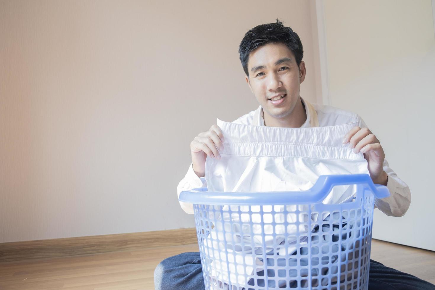 homem asiático dobrando roupa foto