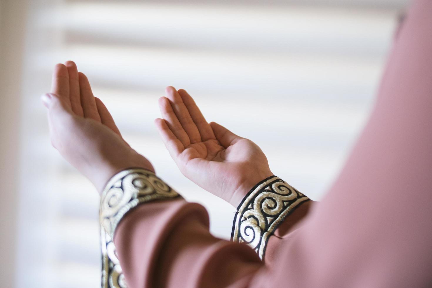 mãos de uma mulher muçulmana ou islâmica gesticulando enquanto orava em casa foto