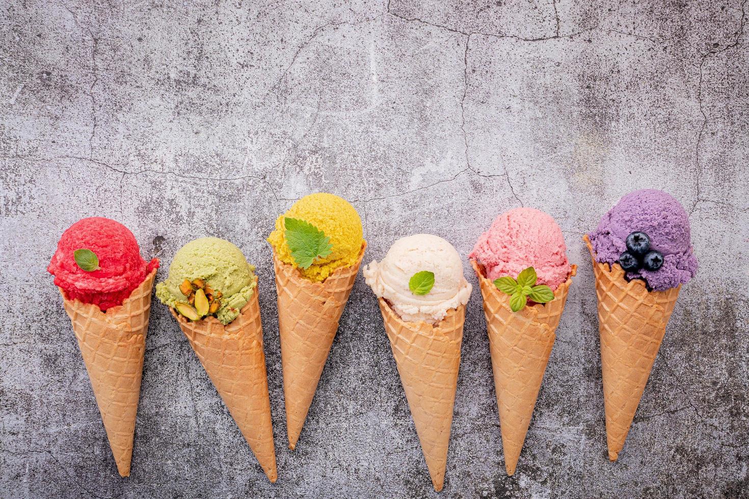 sorvete colorido em cones no fundo de concreto foto