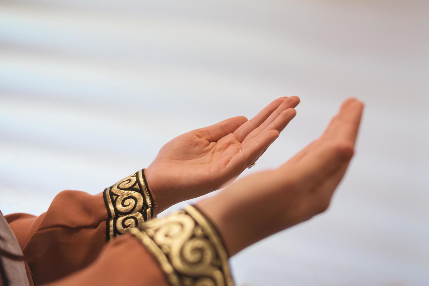 mãos de uma mulher muçulmana ou islâmica gesticulando enquanto orava em casa foto
