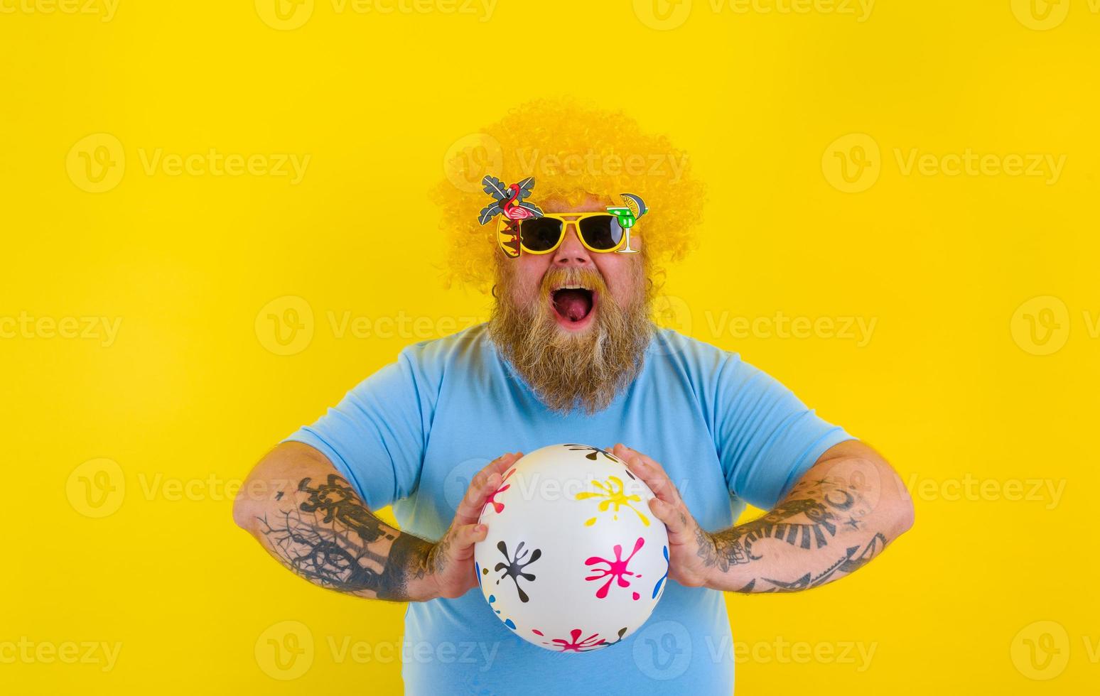 gordo homem com peruca dentro cabeça e oculos de sol ter Diversão com uma bola foto