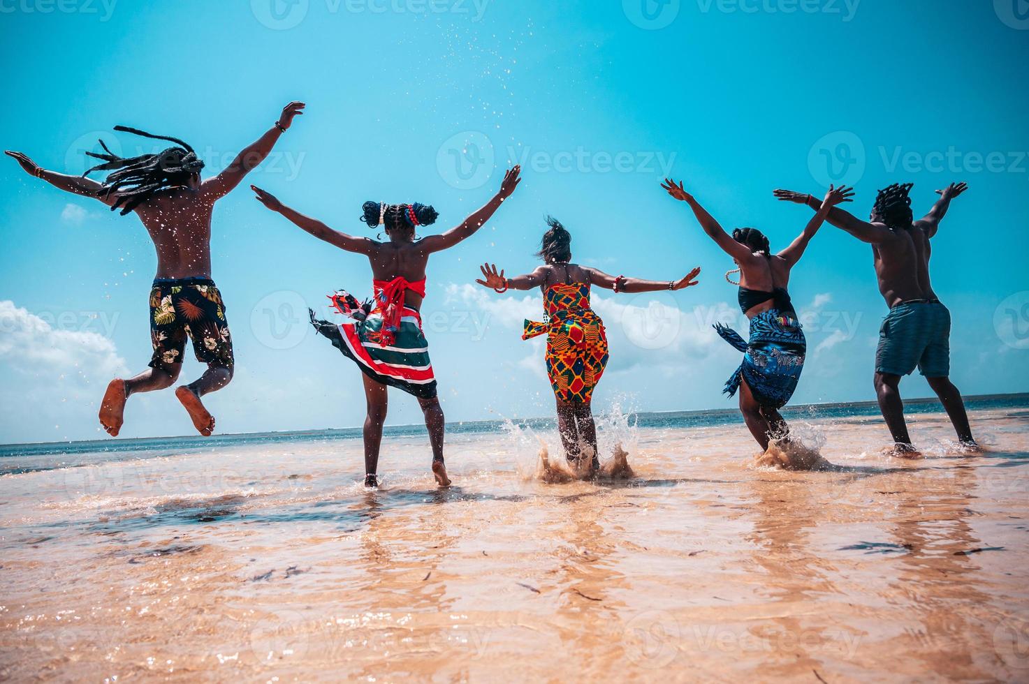 feliz pessoas pulando às a ensolarado mar foto