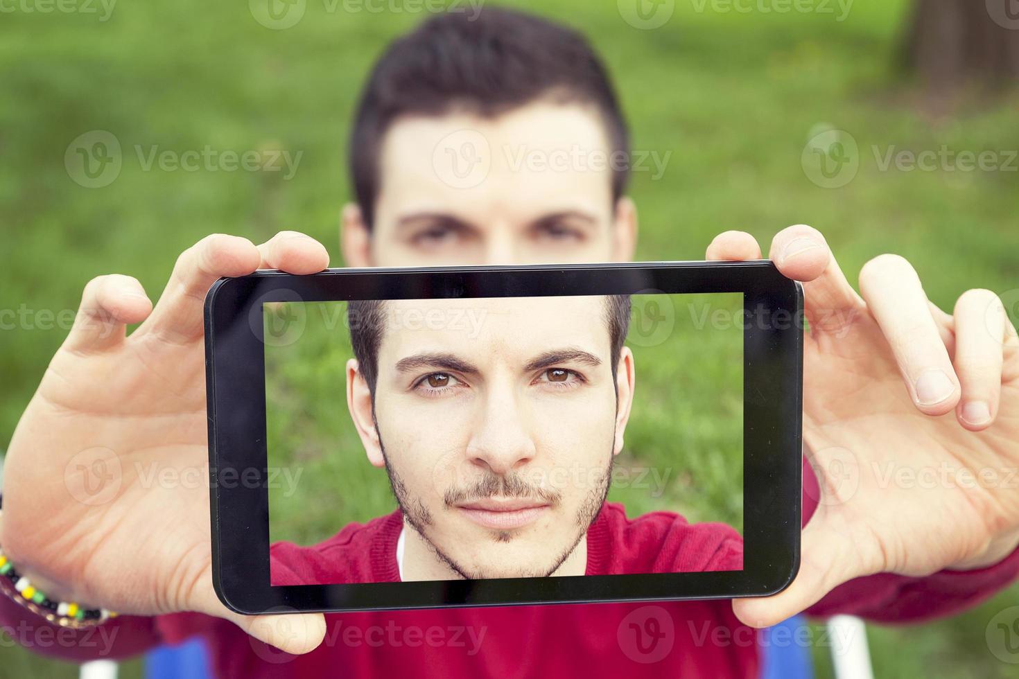 bonito jovem adulto levar uma selfie com inteligente telefone foto