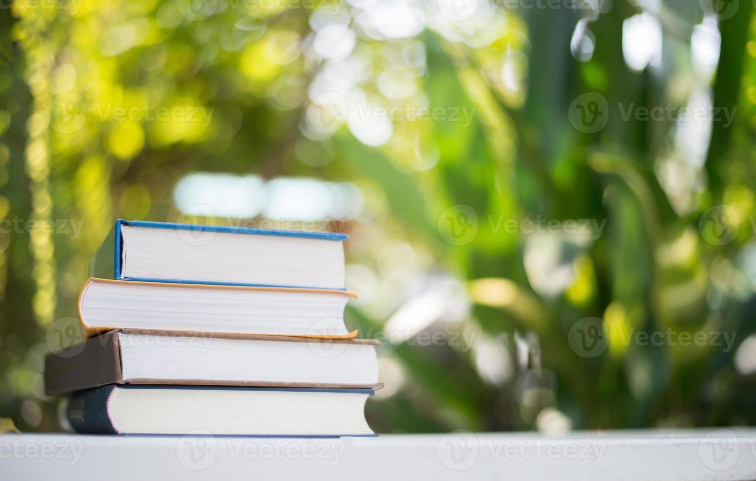 feche uma pilha de livros, filmado ao ar livre sob um fundo de bokeh natural claro foto