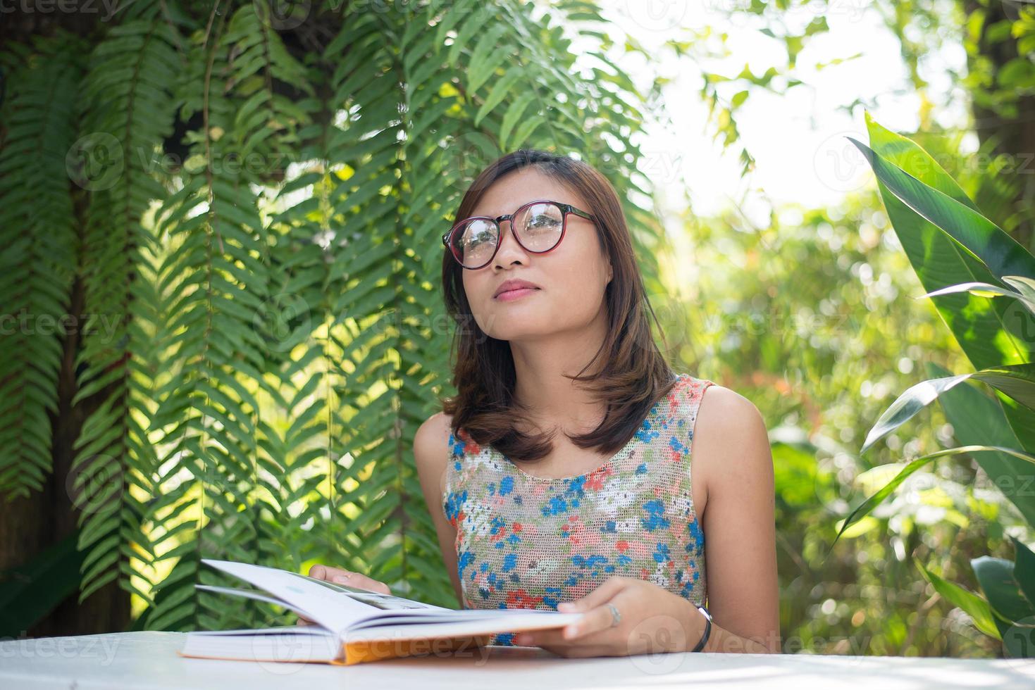 mulher jovem hippie lendo livros no jardim doméstico com a natureza foto