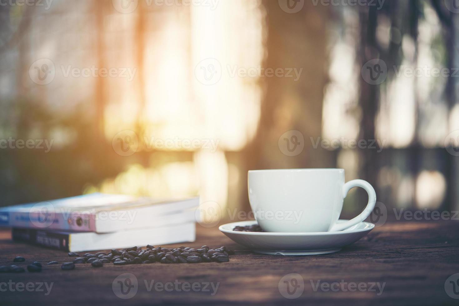 xícara de café com pilha de livros sobre fundo natural de manhã foto