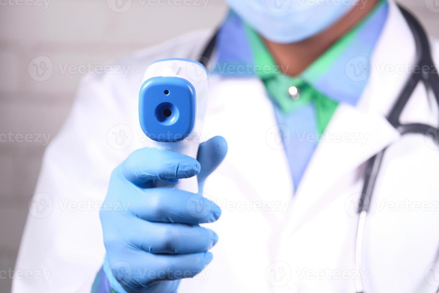 mão do médico com termômetro verificando a temperatura foto