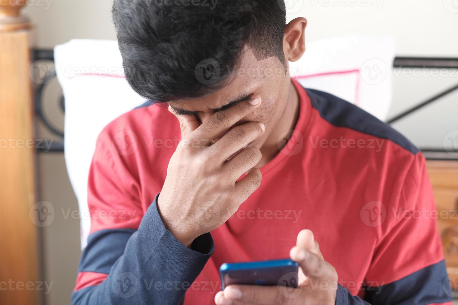 homem chateado olhando para o telefone inteligente foto